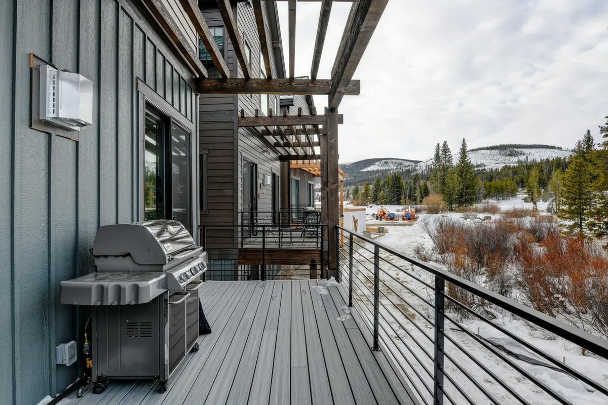 A scenic deck with a grill, wooden beams, and a panoramic mountain view. The space is perfect for barbecues, sipping morning coffee, or simply enjoying nature with your pet at your side.