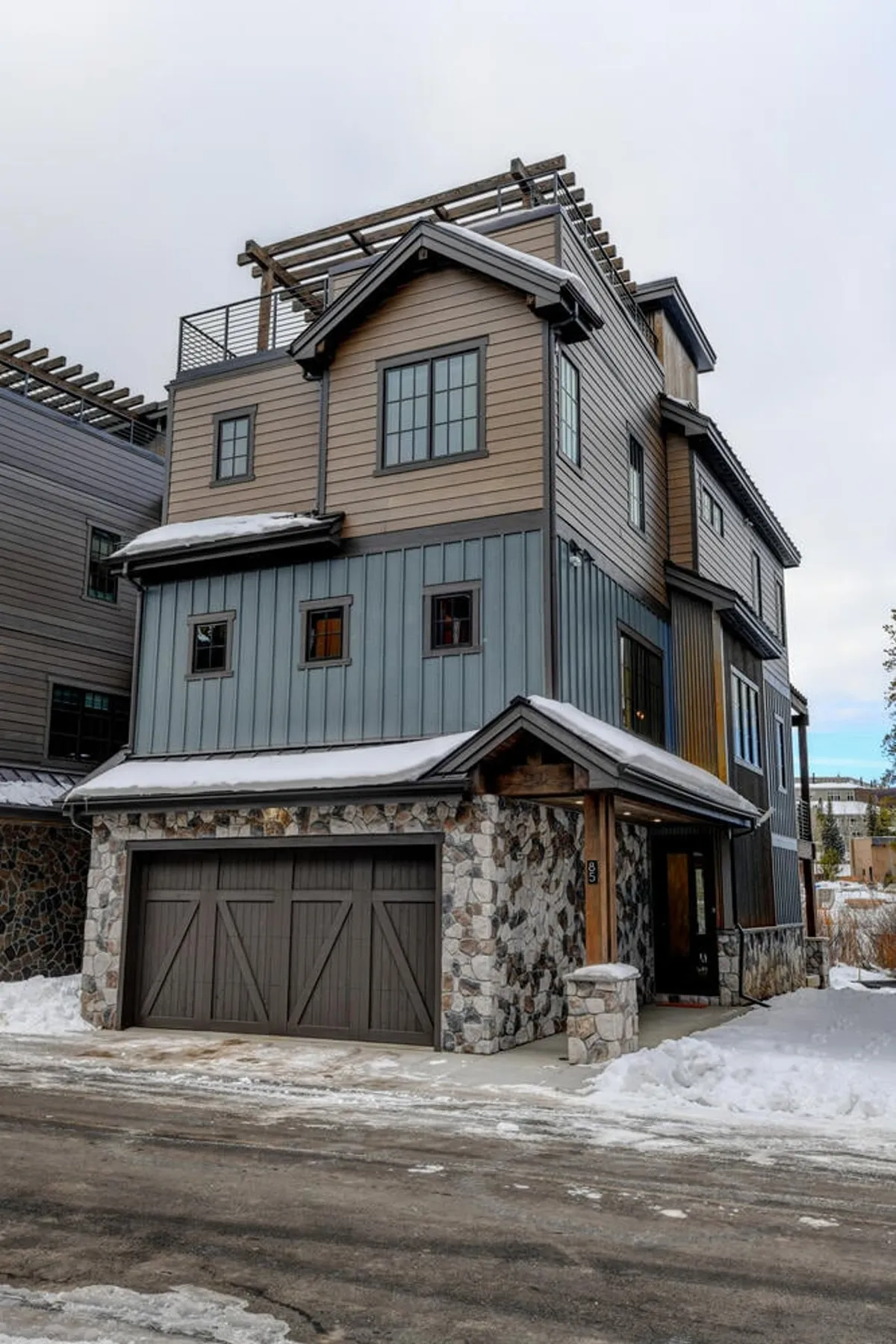 The villa’s exterior with a striking stone facade, wooden accents, and multiple levels. The image captures a sense of scale and warmth, inviting guests to imagine large gatherings and family celebrations both inside and out.